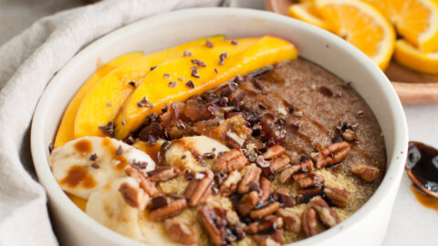 teff porridge in a white bowl with fruit topping