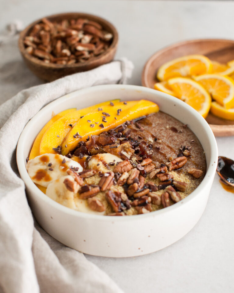teff porridge in a white bowl with fruit topping