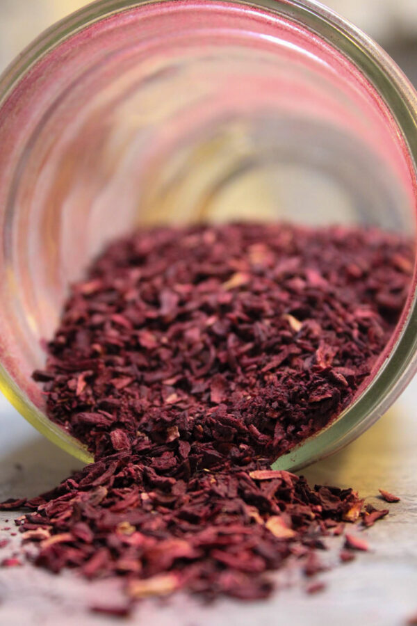 Dried hibiscus spilling out of jar