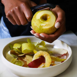Peeling apples into a white bowl