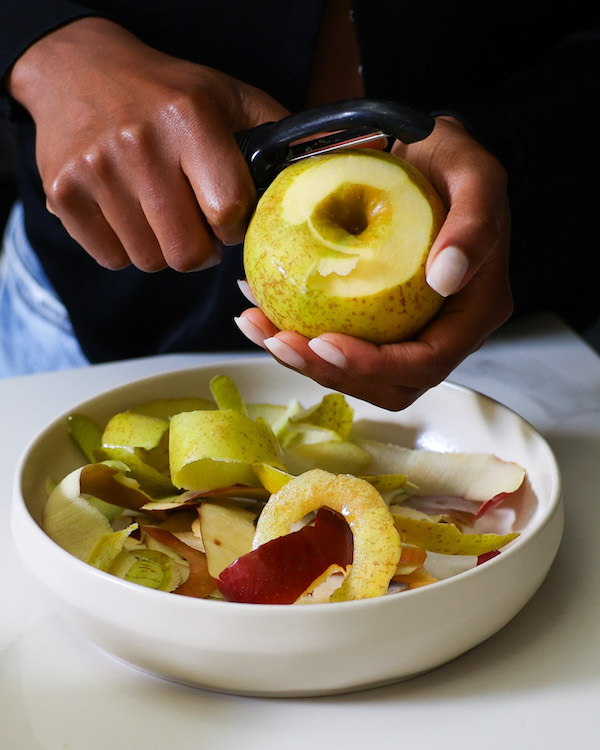 Peeling apples into a white bowl