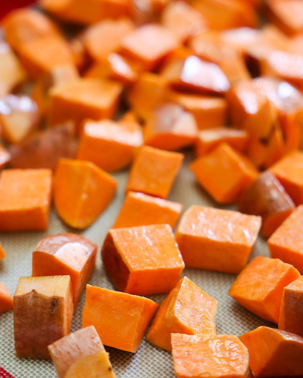 Raw sweet potatoes on a baking sheet