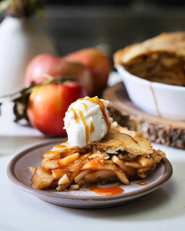 vegan apple pie topped with vegan vanilla ice cream ready to eat