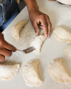 image of jenne sealing the sides of the empanadas with a fork
