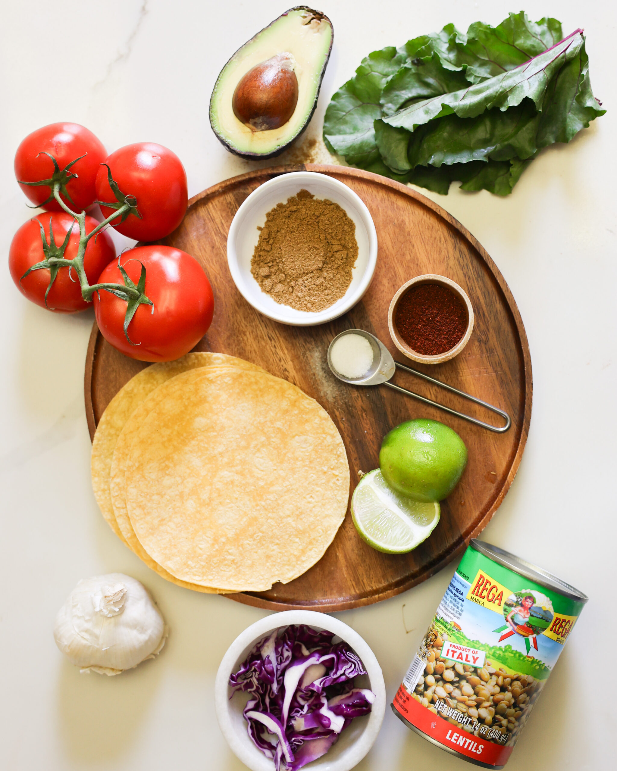 Overhead of lentil taco ingredients on a wooden serve board