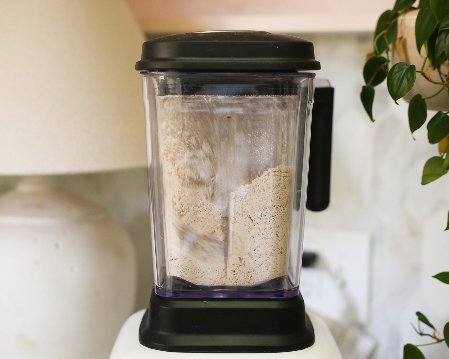 Blending oats to make flour in a blender.