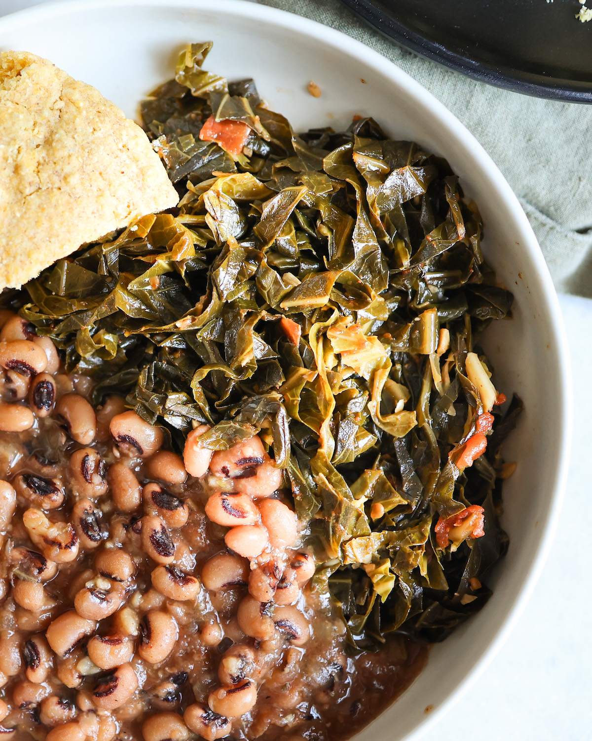 close up of collard greens and black eyed peas in a white bowl