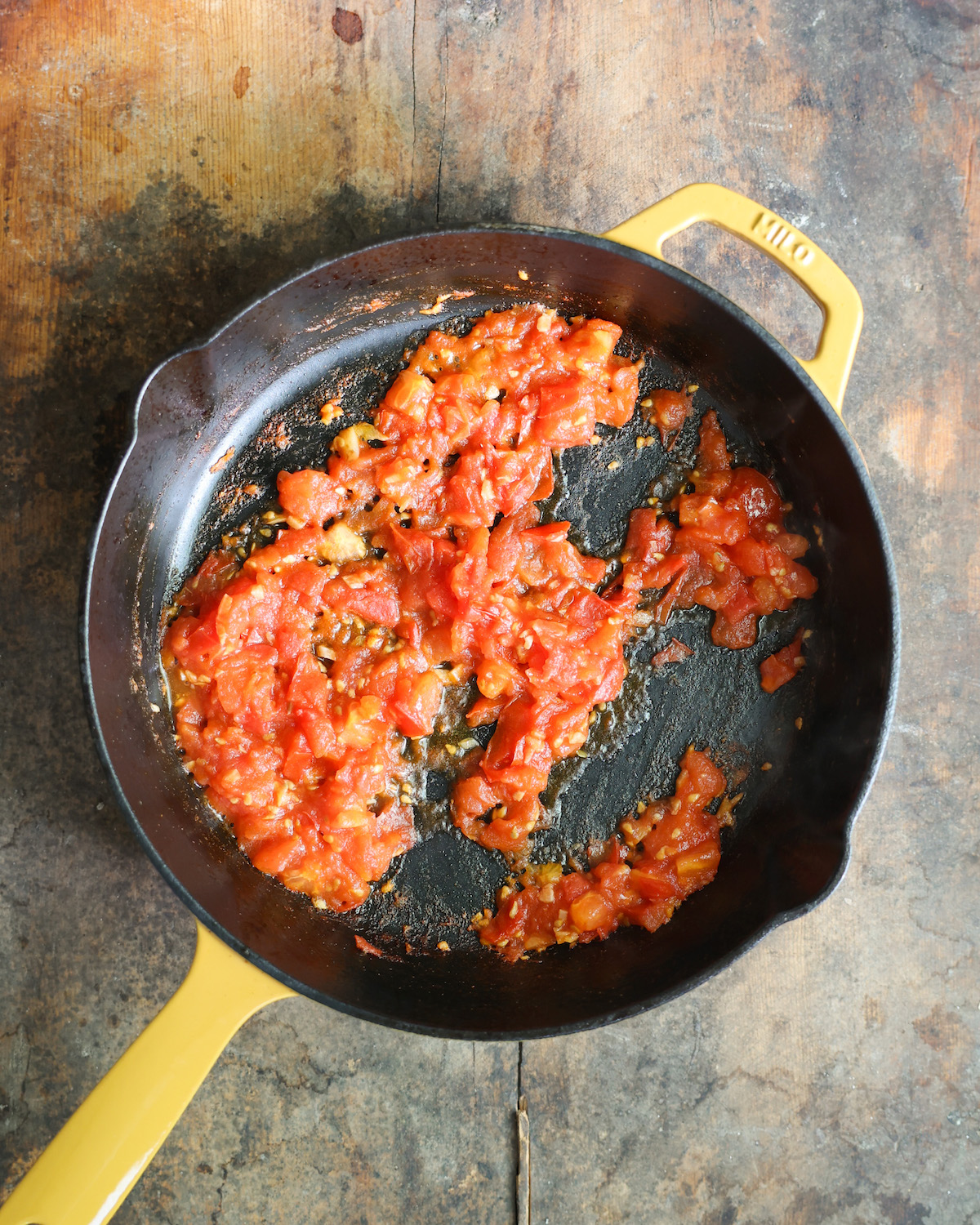 an overhead of tomatoes sautéed in a skillet