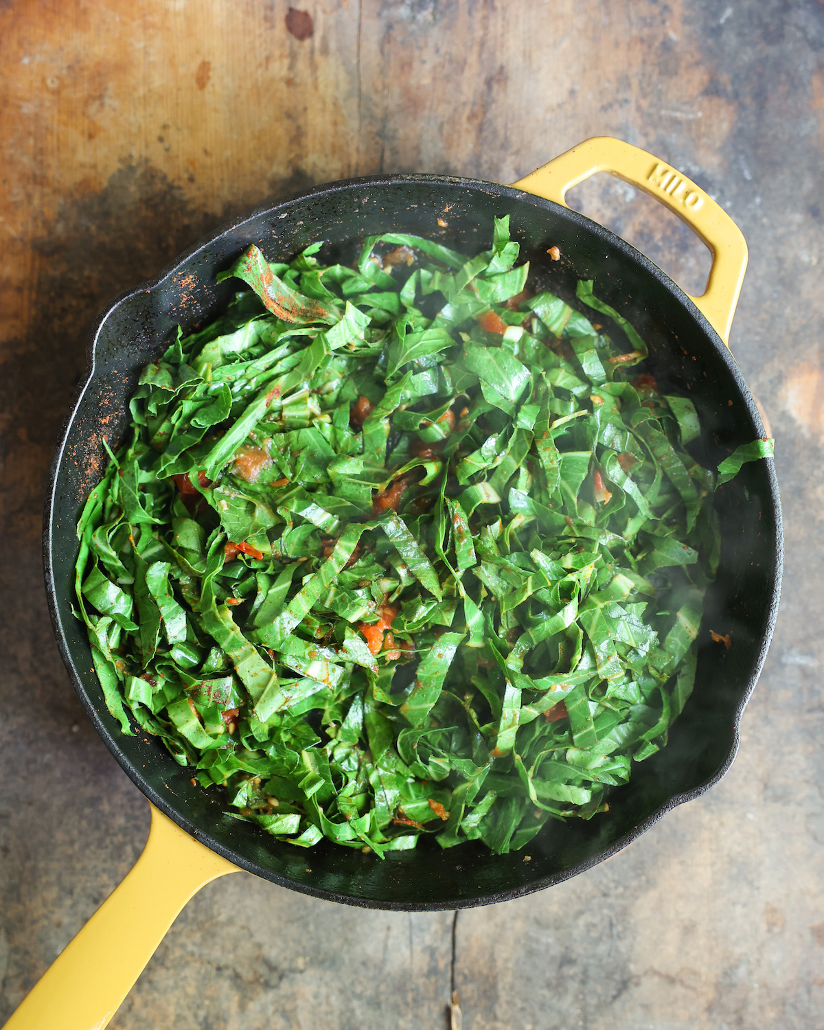 Collard greens sautéing in skillet.