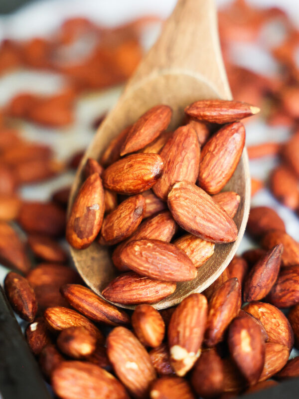 A close up of roasted tamari almonds on a baking sheet.