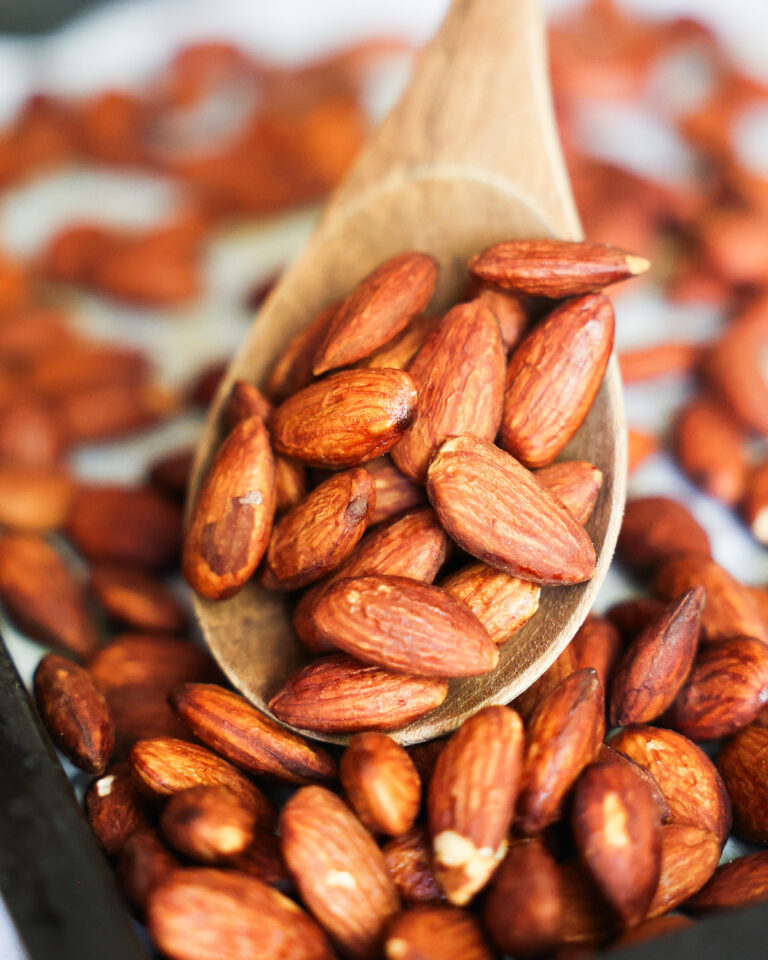 A close up of roasted tamari almonds on a baking sheet.