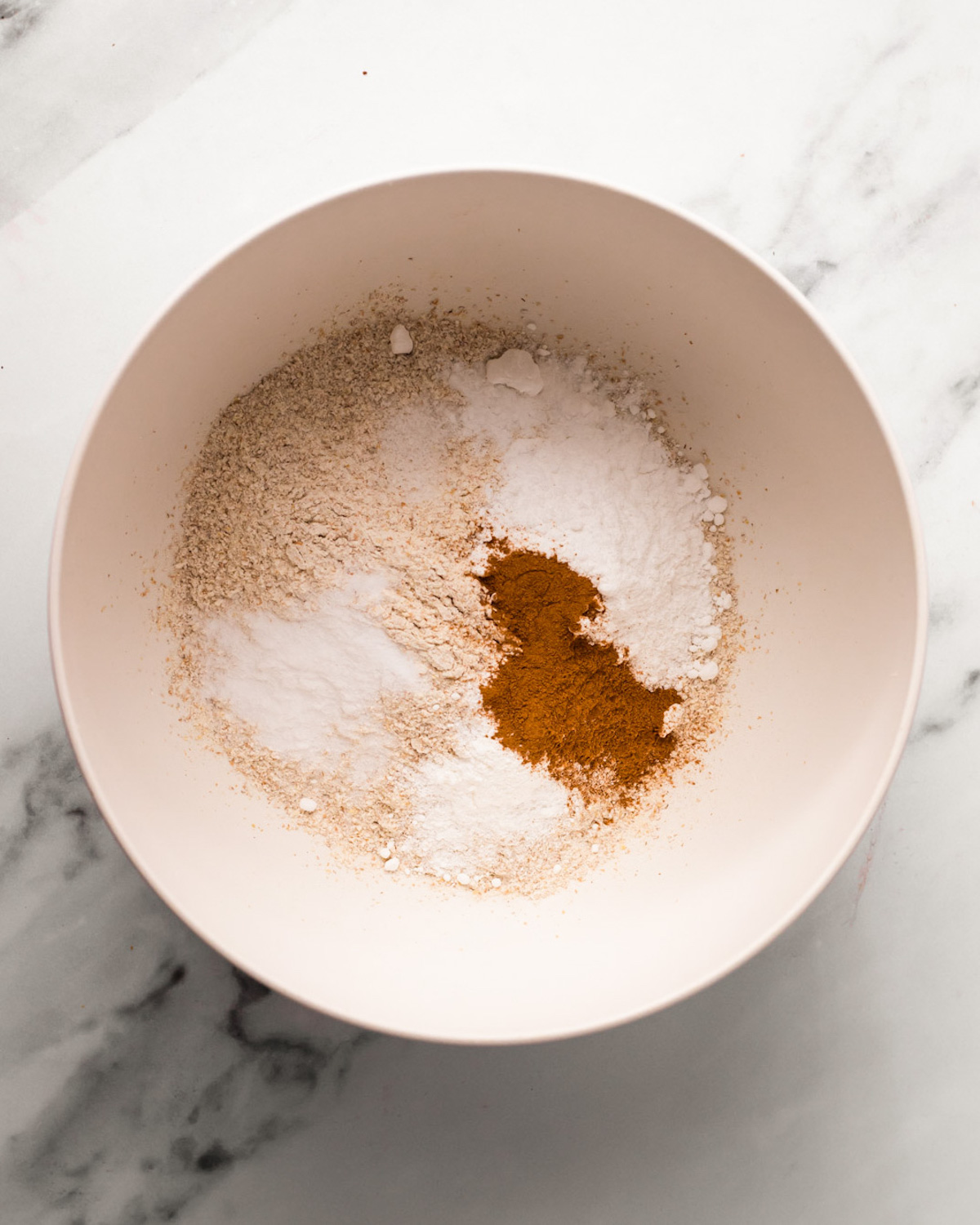An overhead shot of a bowl of flour, spices, and salt.