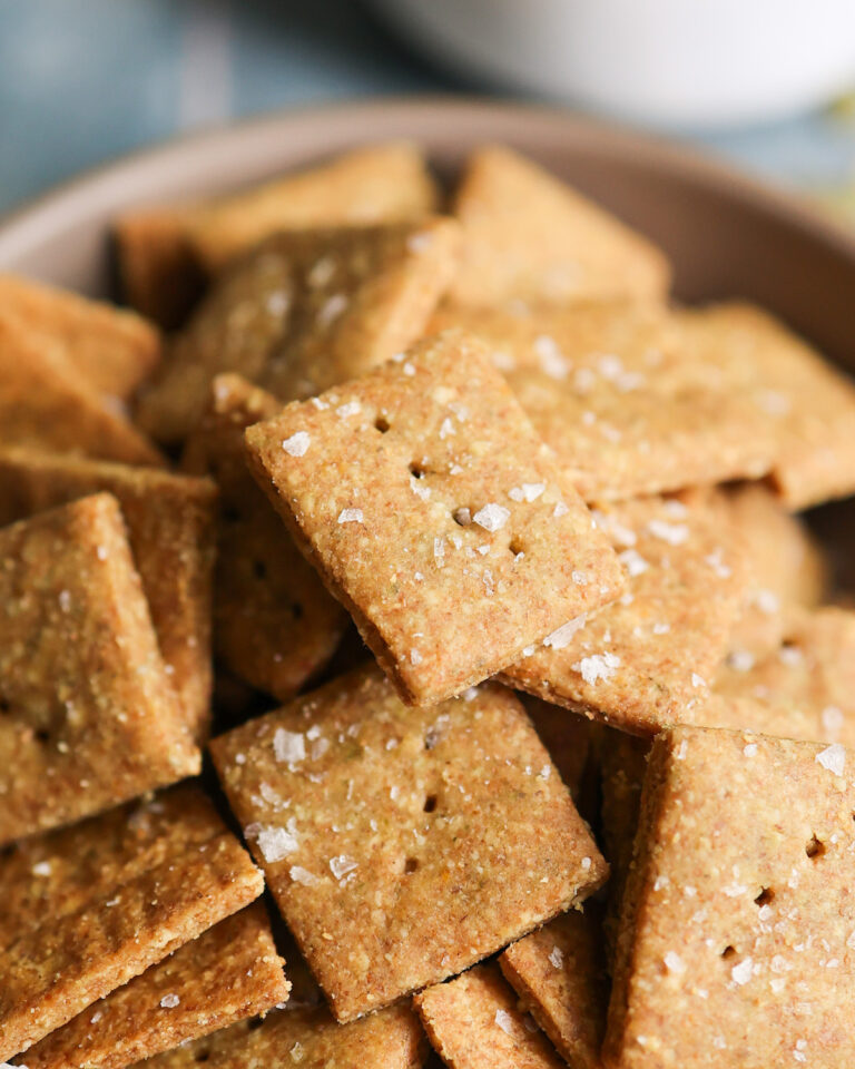 An up-close shot of "cheesy" pumpkin seed crackers in a bowl.
