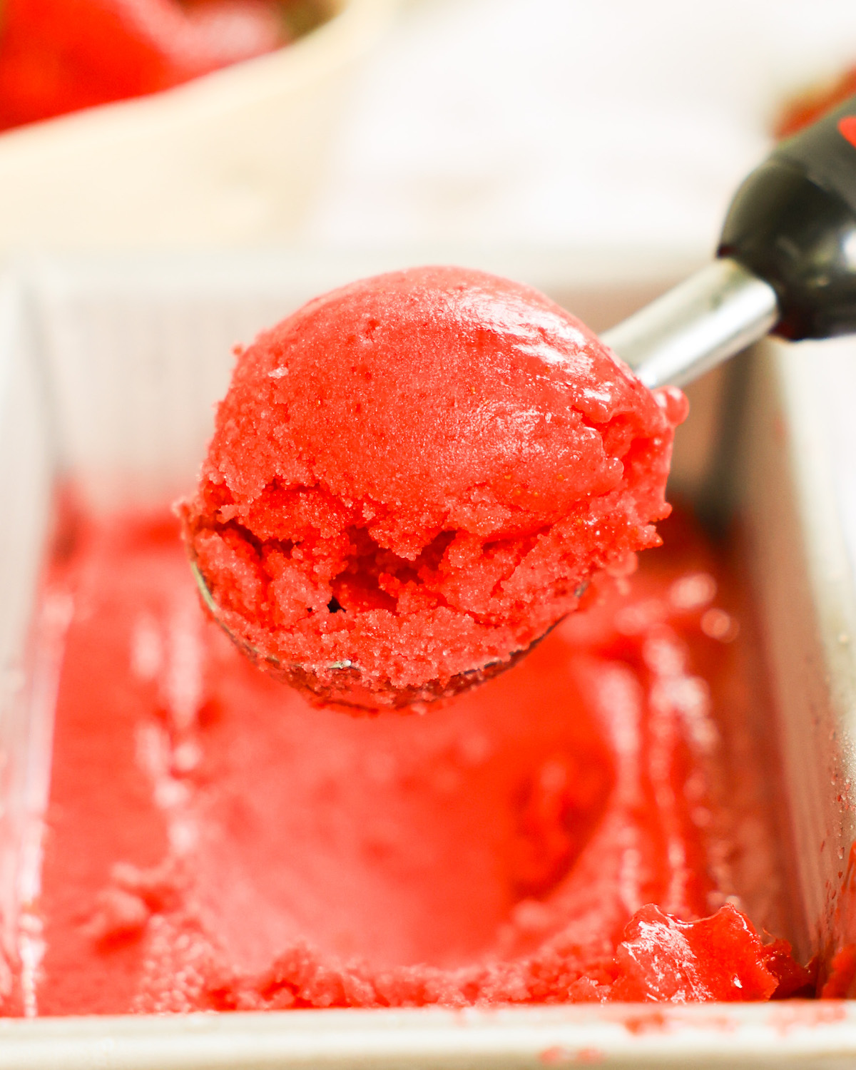 An up-close shot of a scoop of strawberry sorbet.