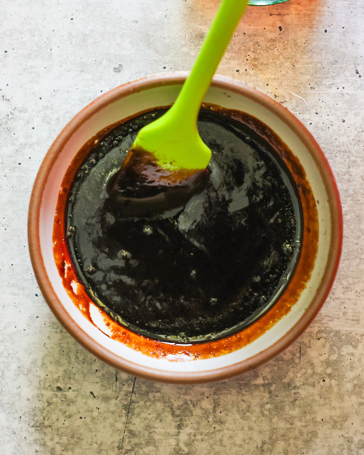 balsamic glaze in a small bowl with green spatula