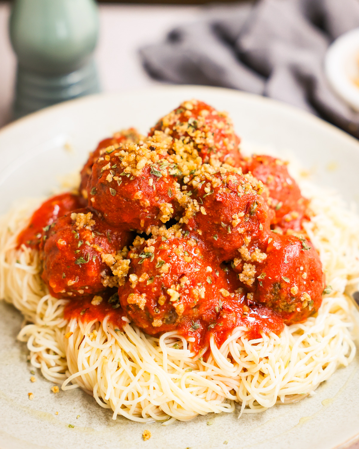 vegan meatballs stacked on a bed of spaghetti