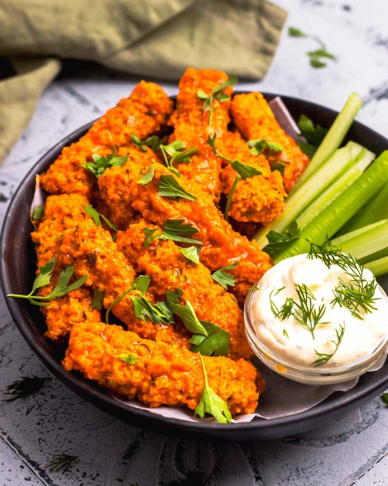 side view of vegan buffalo wings on a plate with celery and dairy-free ranch dip