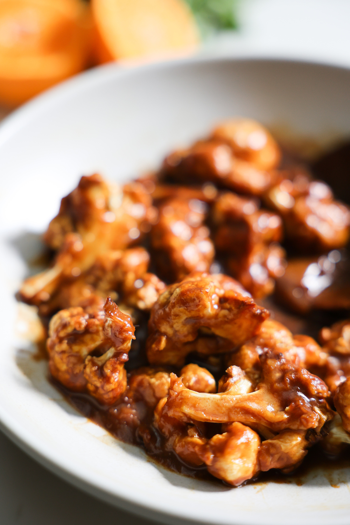 A closeup shot of the orange cauliflower in a white bowl.