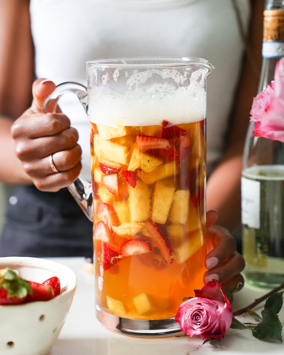 Jenné holding a pitcher of white wine sangria.
