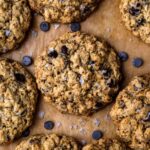 Closeup of Vegan Oatmeal Chocolate Chip Cookies on brown parchment
