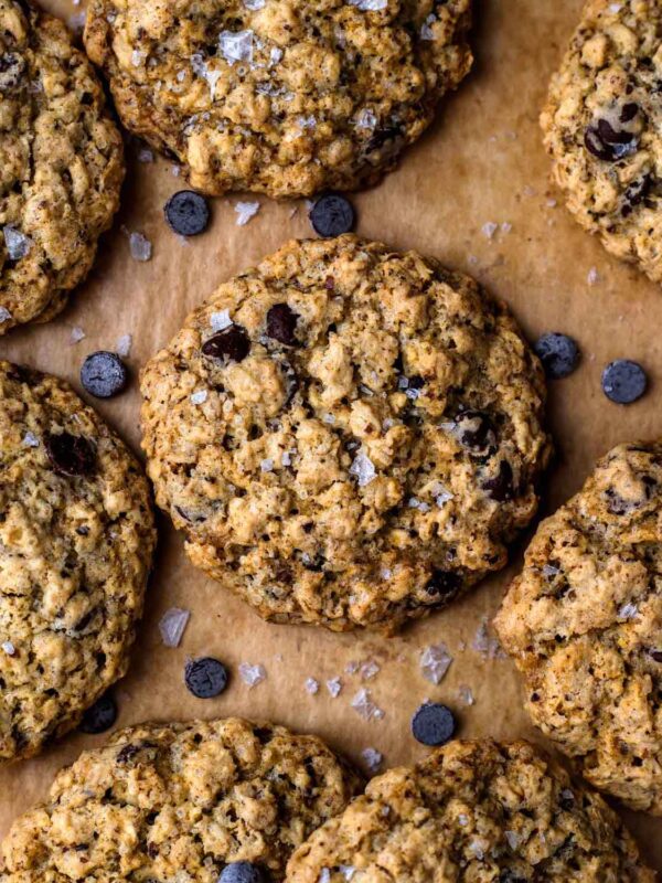 Closeup of Vegan Oatmeal Chocolate Chip Cookies on brown parchment