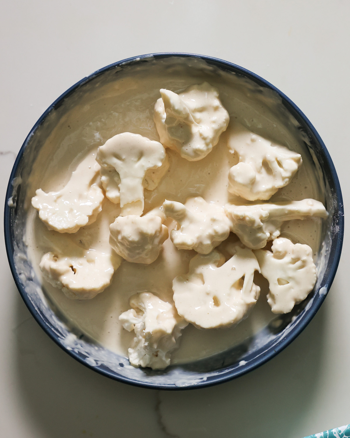 The cauliflower in the wet batter.