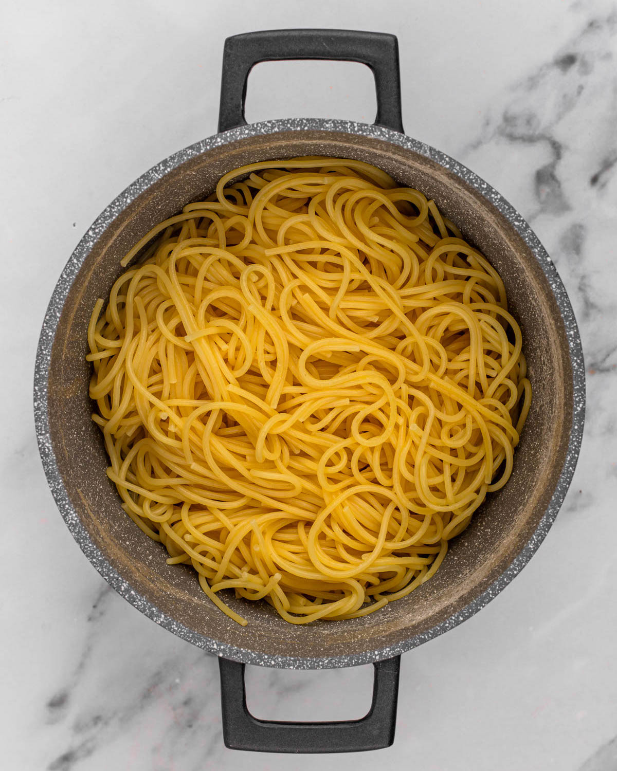 overhead of cooked and drained pasta in pot