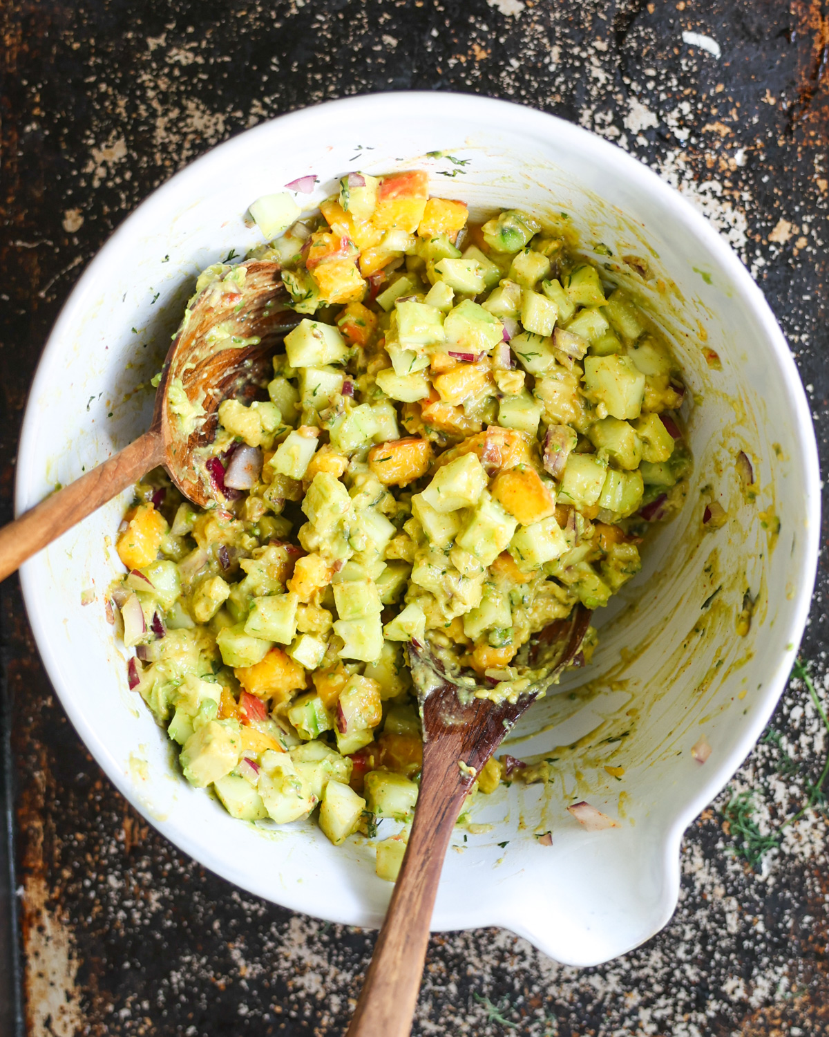 overhead of cucumber avocado salad in mixing bowl