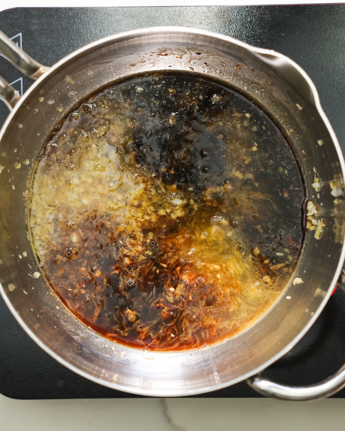 An overhead shot of the ingredients for the orange sauce in a saucepan.