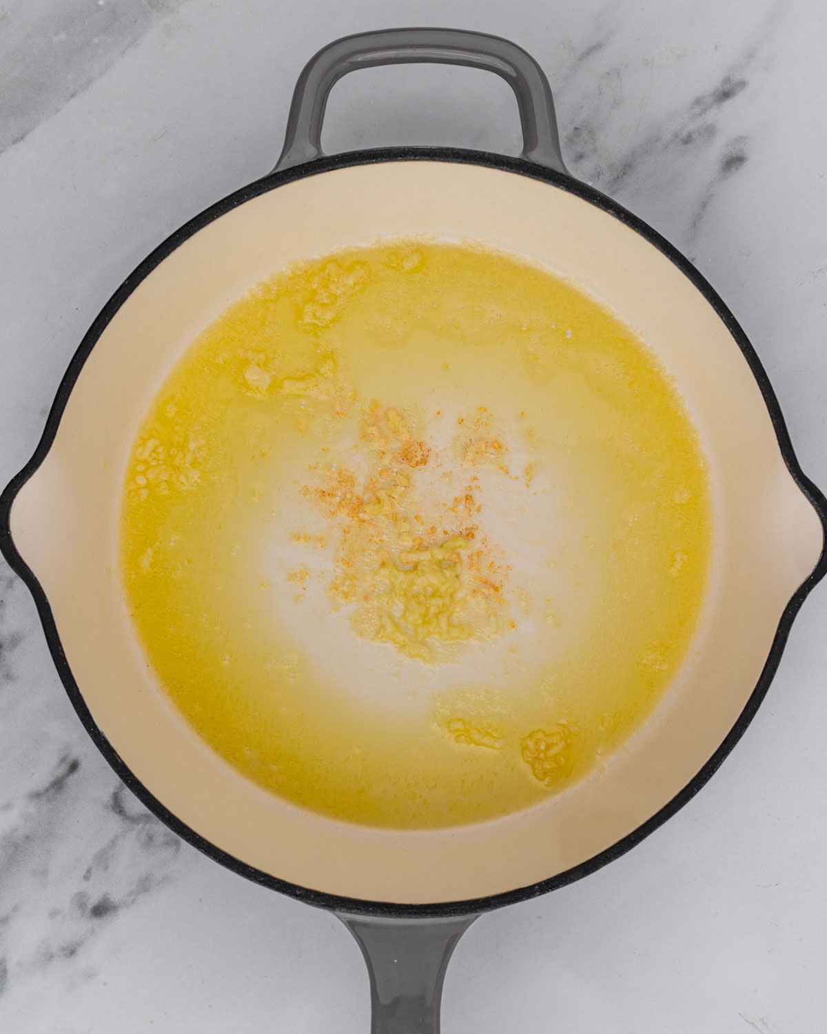 overhead of garlic sautéing in pan