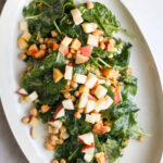 overhead of baby kale salad on white platter