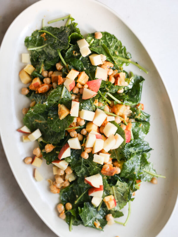 overhead of baby kale salad on white platter