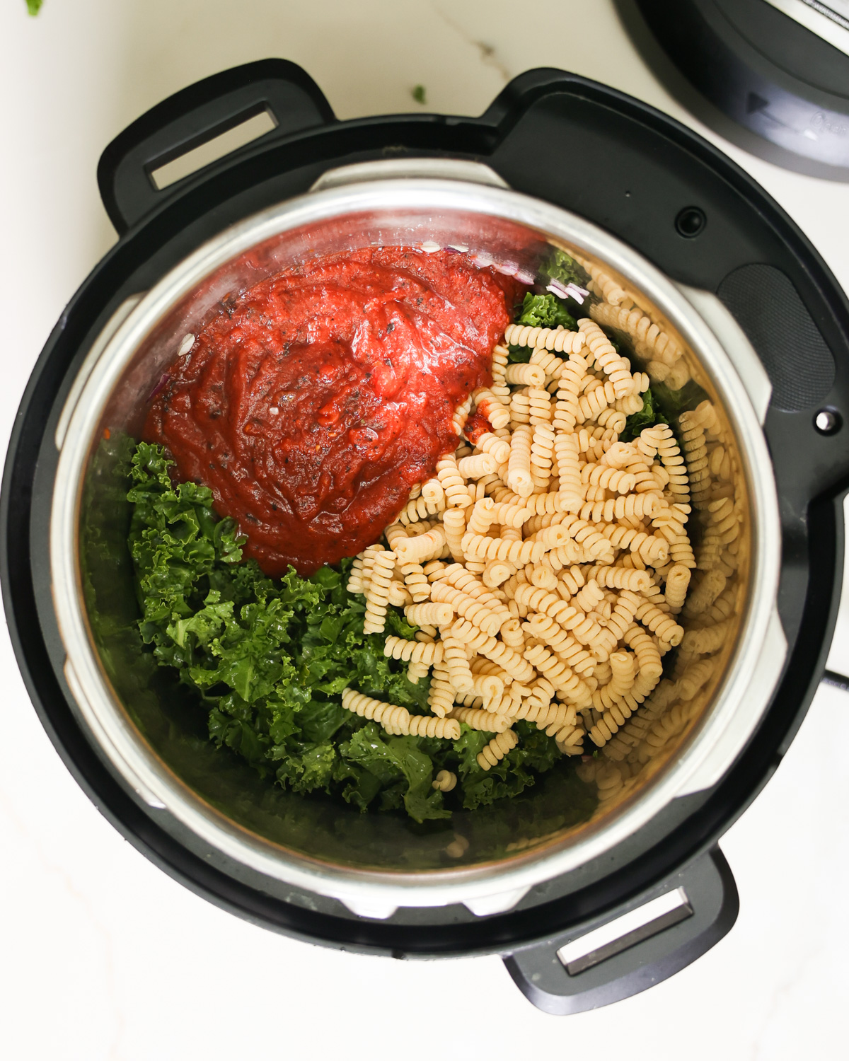 Tomato sauce, kale, and pasta in an Instant Pot.