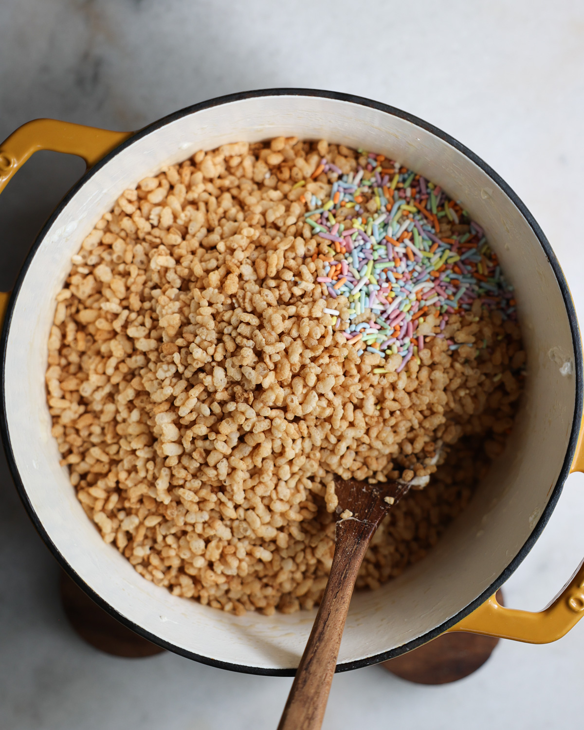 overhead of brown rice crisps added to a pot