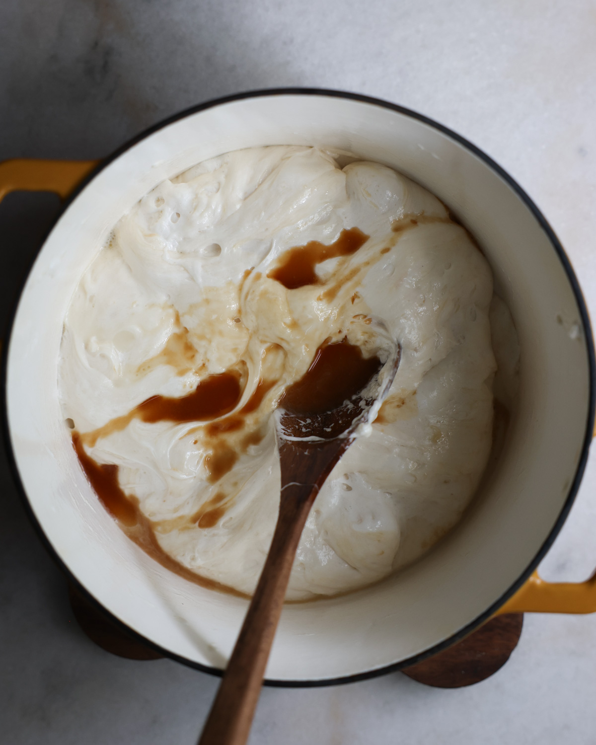 overhead of vanilla added to melted marshmallows in pot