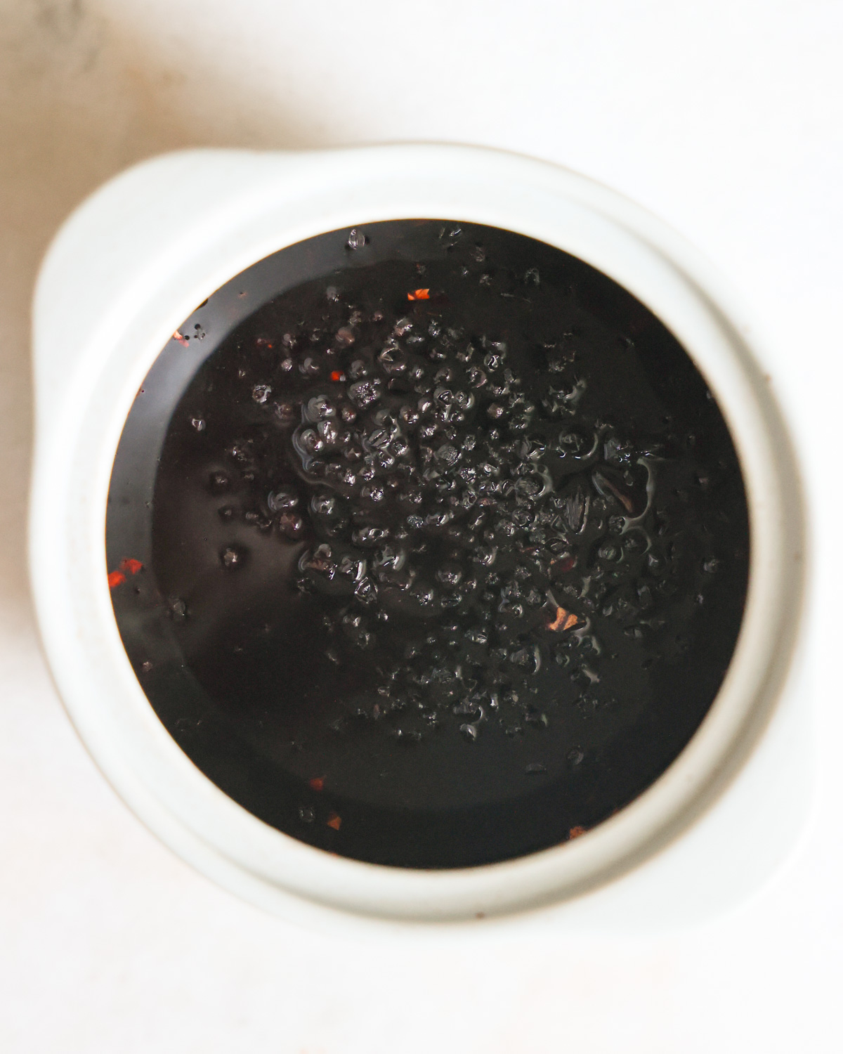 An overhead shot of the elderberries simmered in water with spices.