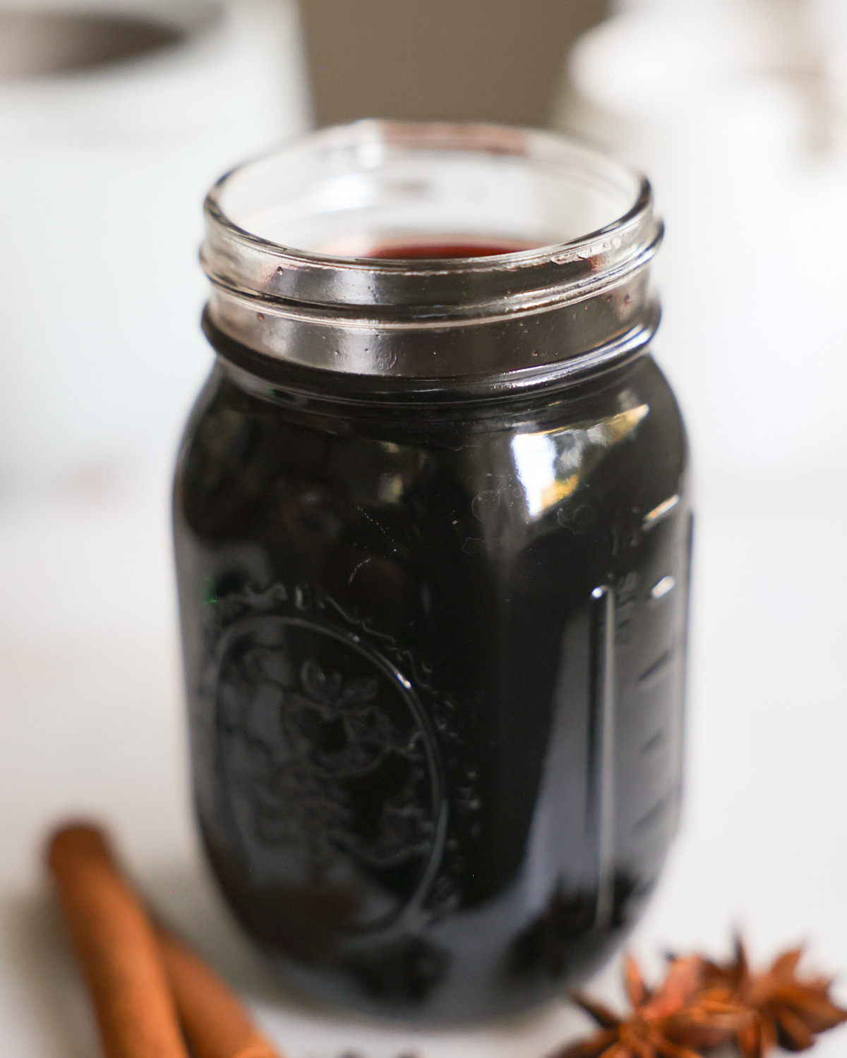 An up-close shot of a small jar of elderberry syrup.