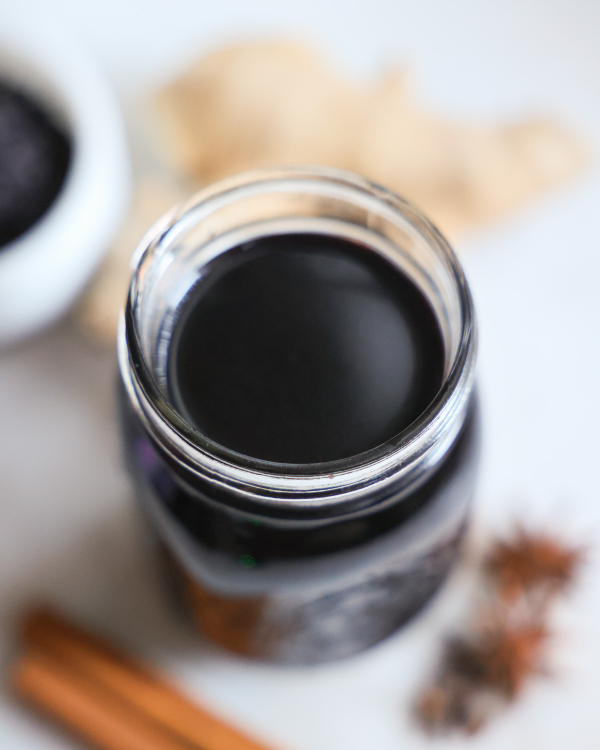 An up-close overhead shot of a small jar of elderberry syrup.