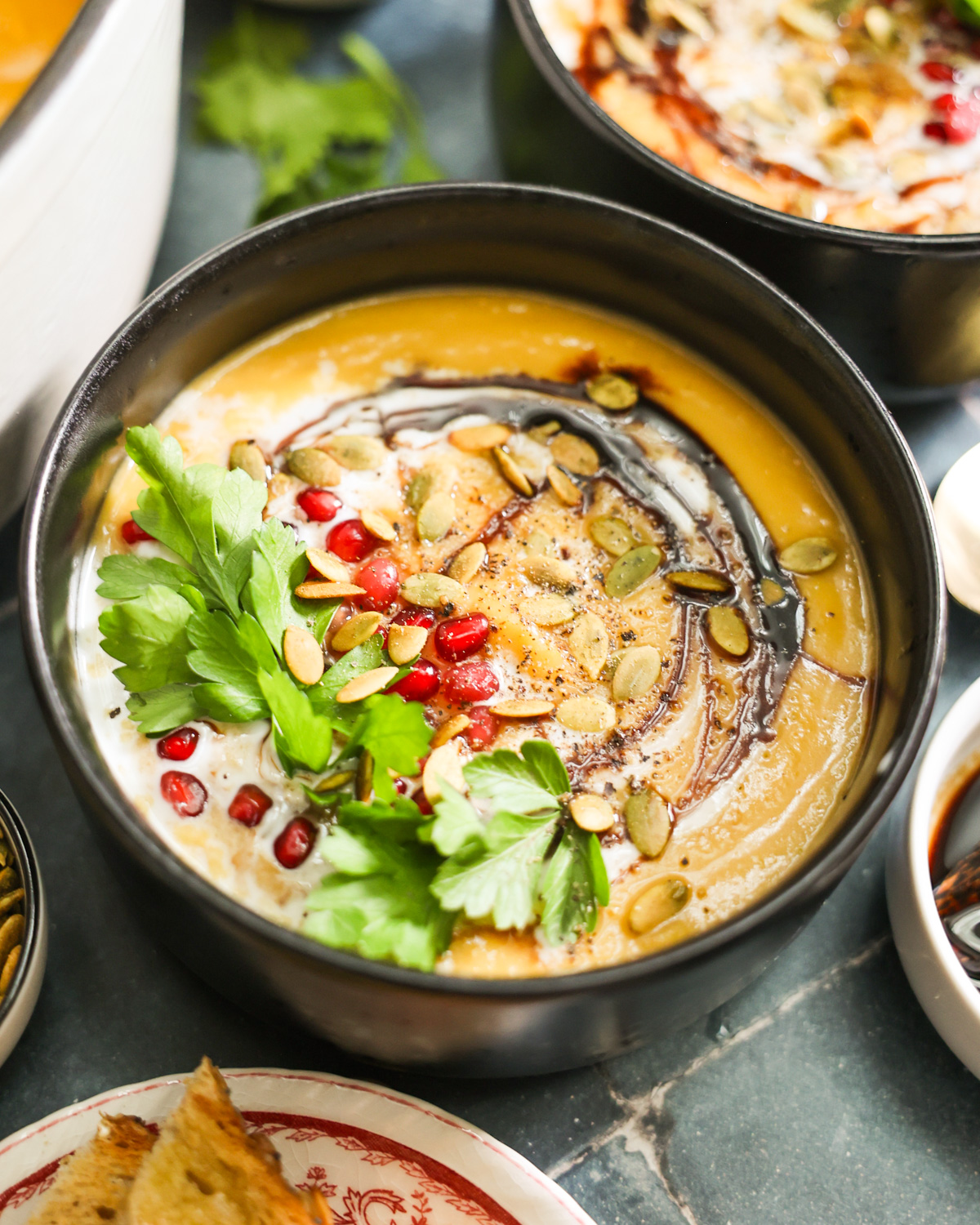 Vegan Butternut Squash Soup topped with coconut milk and pomegranates