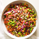An overhead shot of a bowl of edamame salad garnished with chopped almonds.