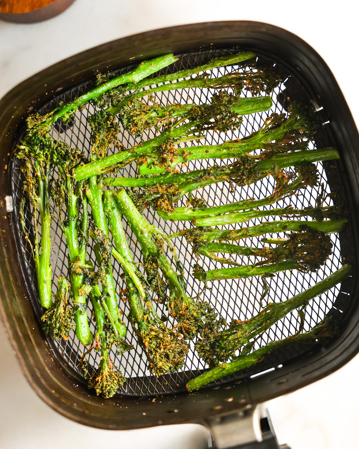 Air fry broccolini in a air fryer basket.