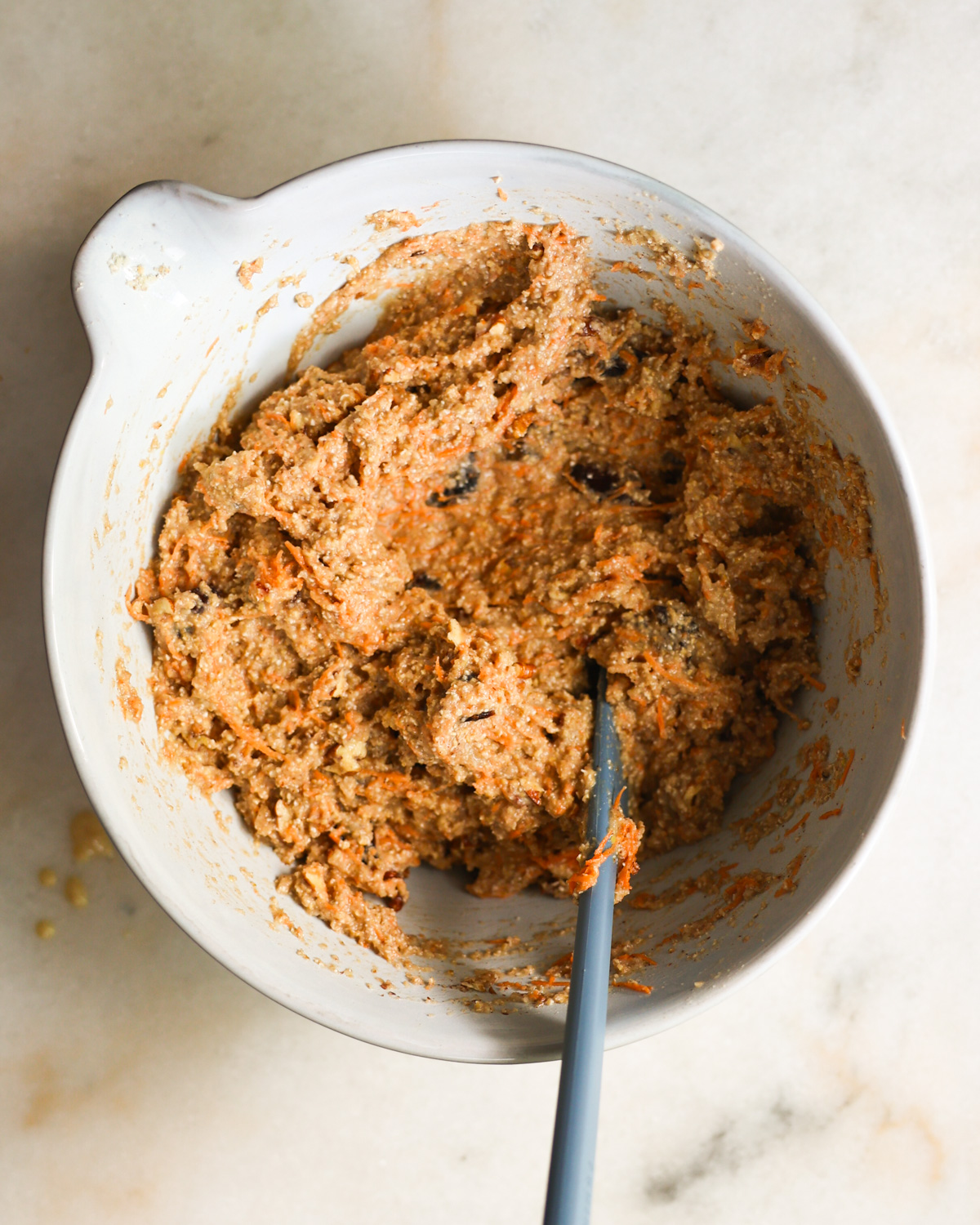 An overhead shot of a mixing bowl of the oat bran muffin batter with sweet potatoes. 