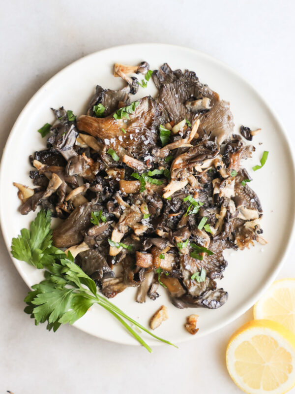 overhead of pan-fried oyster mushrooms recipe on a plate with parsley garnish