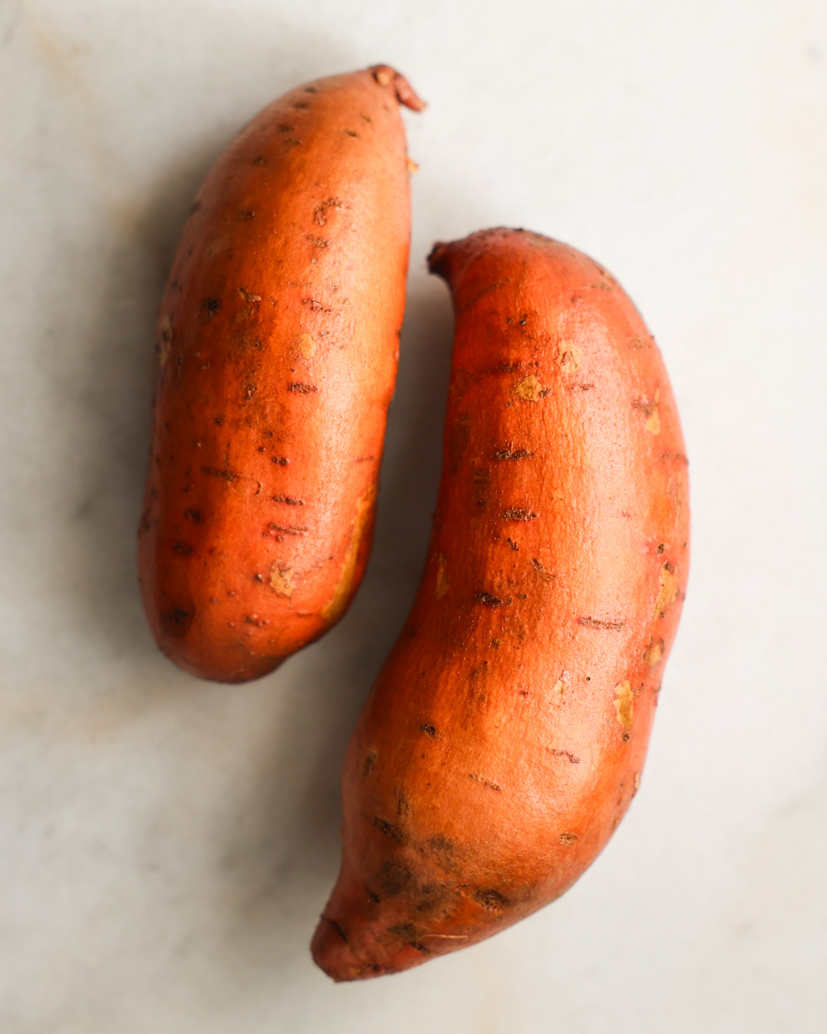 Two washed sweet potatoes on the counter.