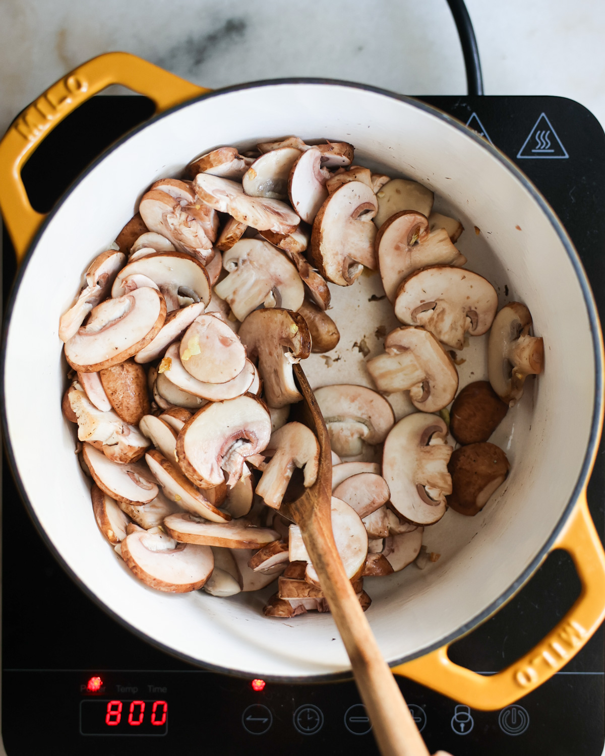 stirring mushrooms in pot