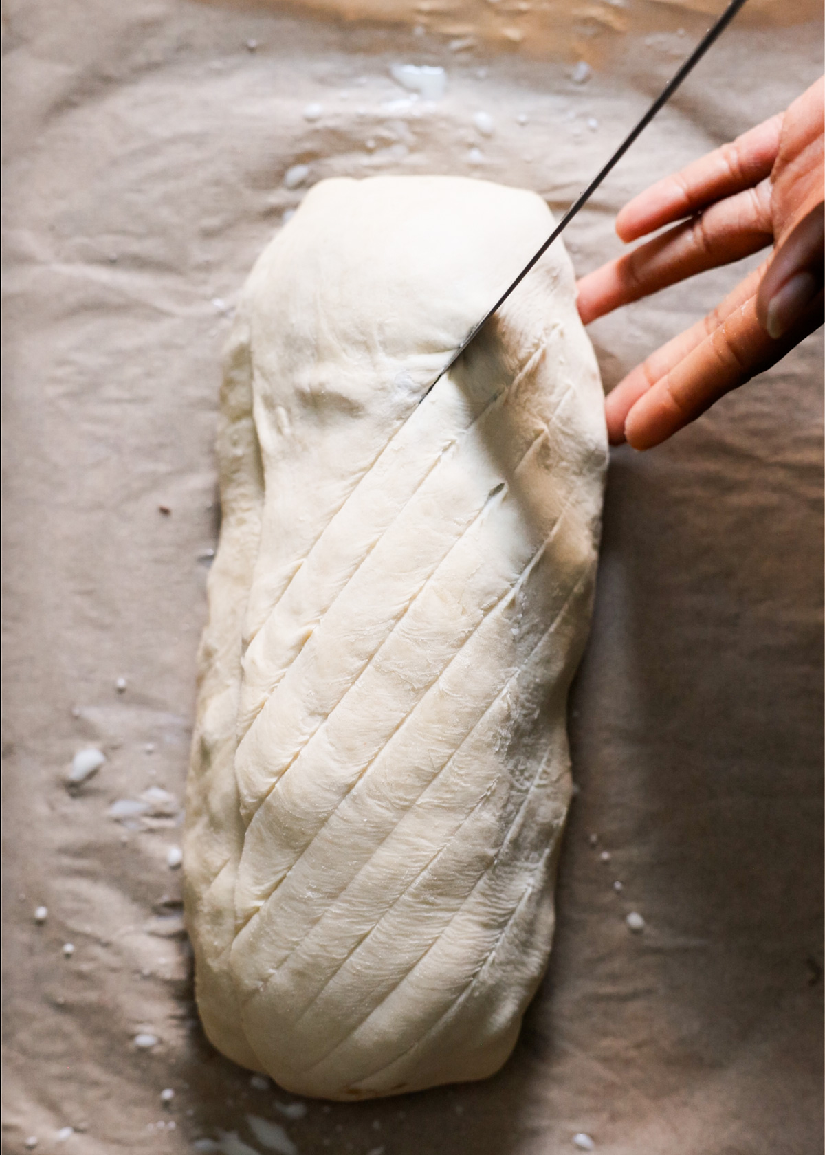 Very carefully cutting a cross pattern into the top of the Wellington pastry.