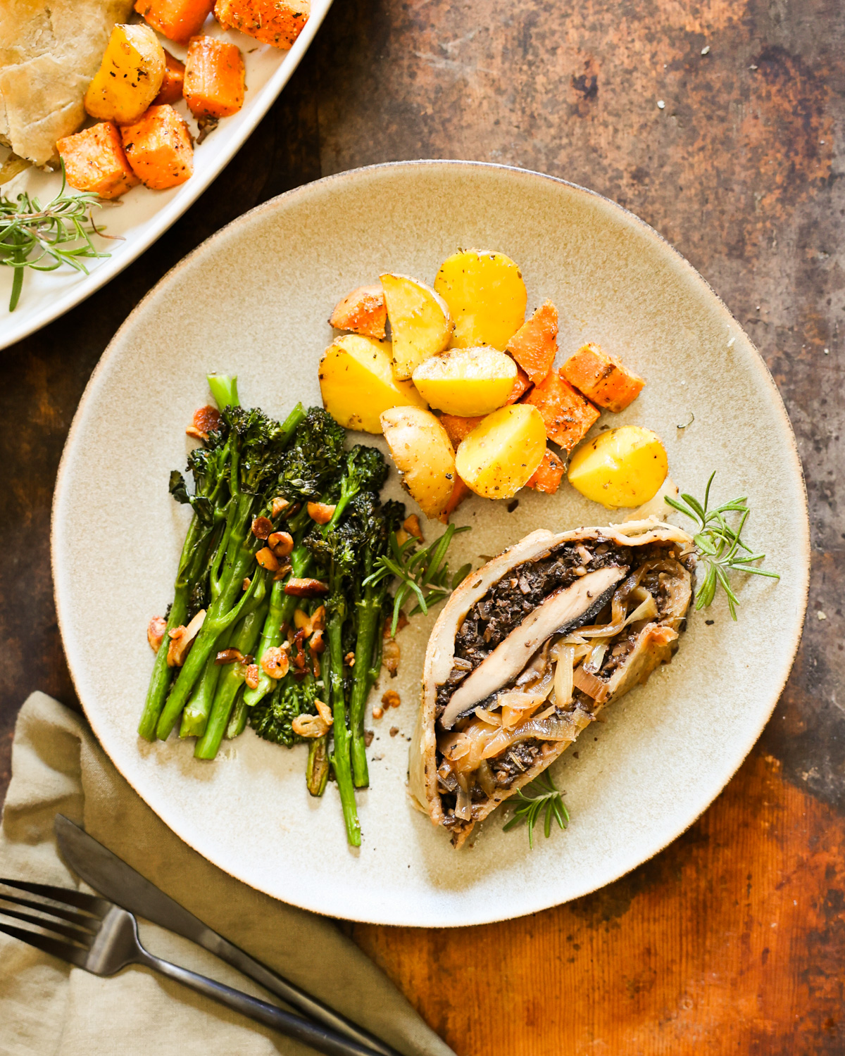 An overhead shot of a dinner plate with a slice of mushroom Wellington with vegetables.