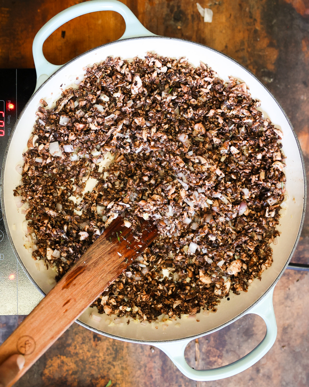 An overhead shot of the chopped mushrooms cooking in a pan.