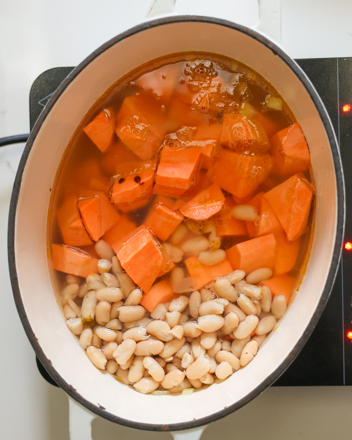 bringing sweet potato soup to simmer