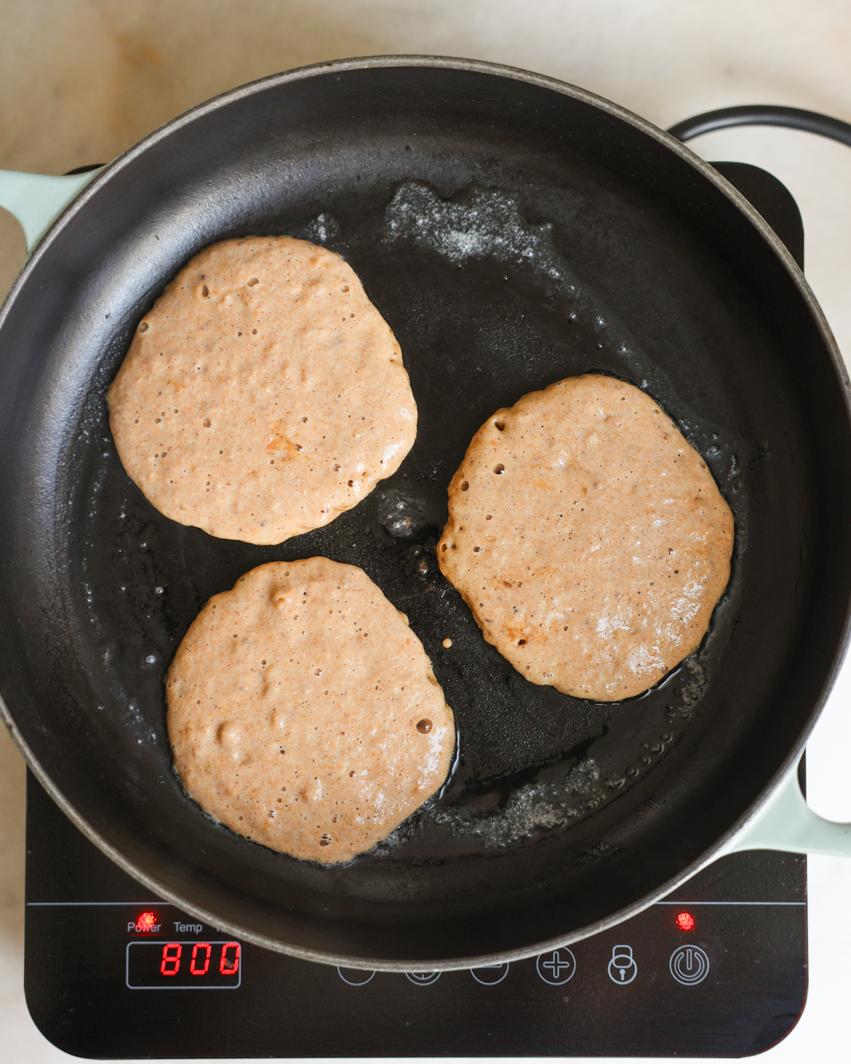 overhead uncooked sides of pancakes in skillet